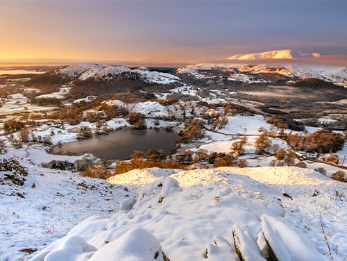 The Lake District on a sunny day during the winter with snow all around.