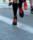 Close-up of legs wearing trainers and long socks running on the road