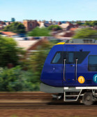 Image shows a blue and white Northern train speedy alongside some green shrubbery.