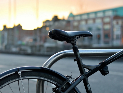 A close-up of the back of bicycle with a city street in the background