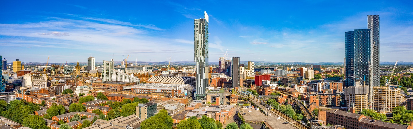 Manchester skyline in the daytime with a mixture of small industrial and high-rise buildings