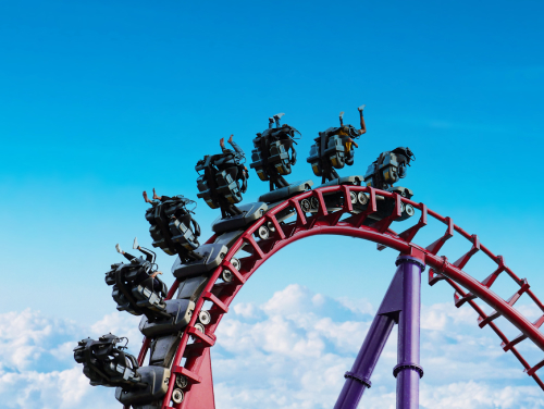 People riding a roller coaster, the coaster has turned them upside down as they go over a loop