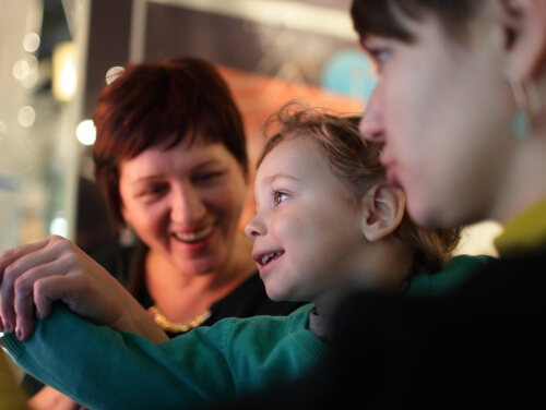 Close-up of two smiling adult women with a child between them